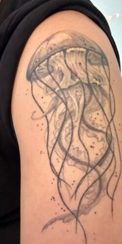 Jellyfish tattoo-min A shoulder tattoo of a jellyfish, its tendrils causing small bubbles to rise